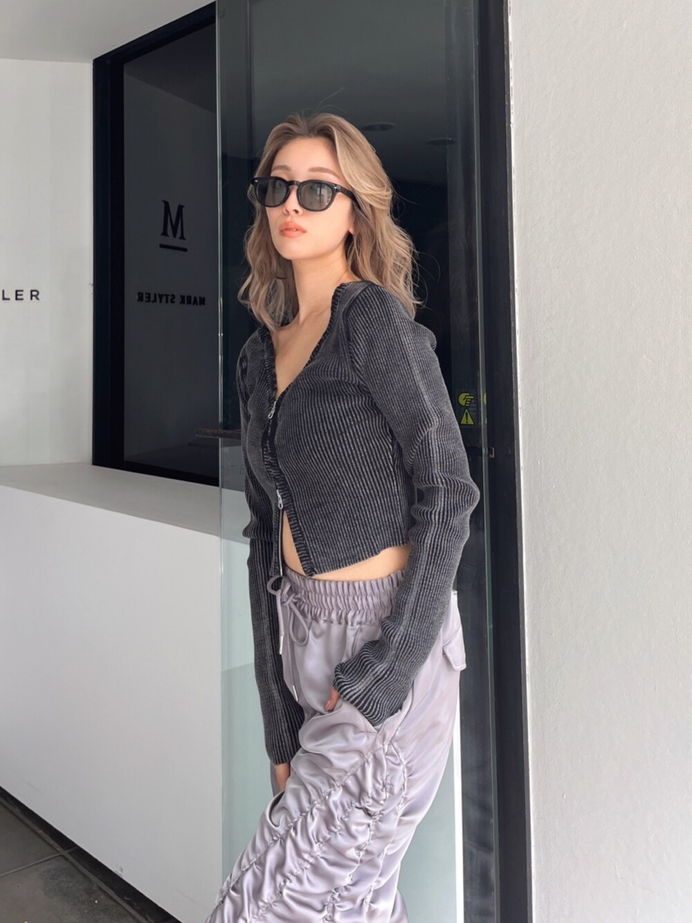 グレー系のその他パンツ、ブラック系のニット/セーター、ブラック系のブーツを着用したレディースの秋コーディネートの5枚目の写真