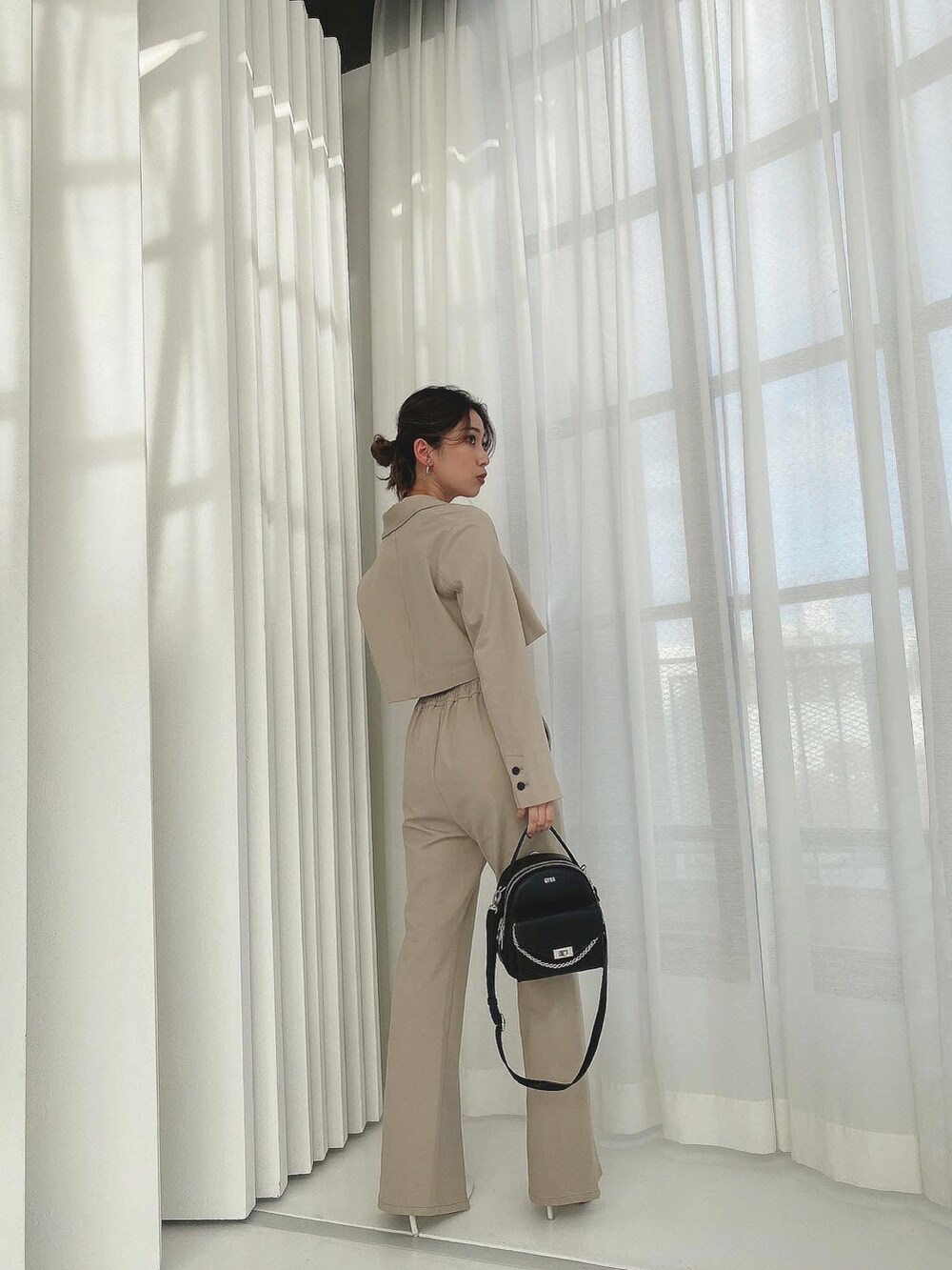 パープル系のテーラードジャケットを着用したレディースの冬コーディネートの3枚目の写真