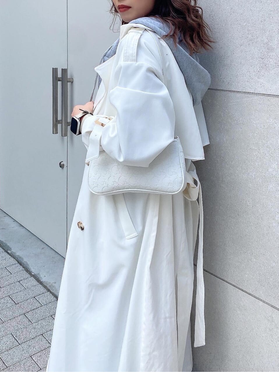 ブラック系のパンプス、ホワイト系のトレンチコート、ホワイト系のニット/セーターを着用したレディースの冬コーディネートの8枚目の写真