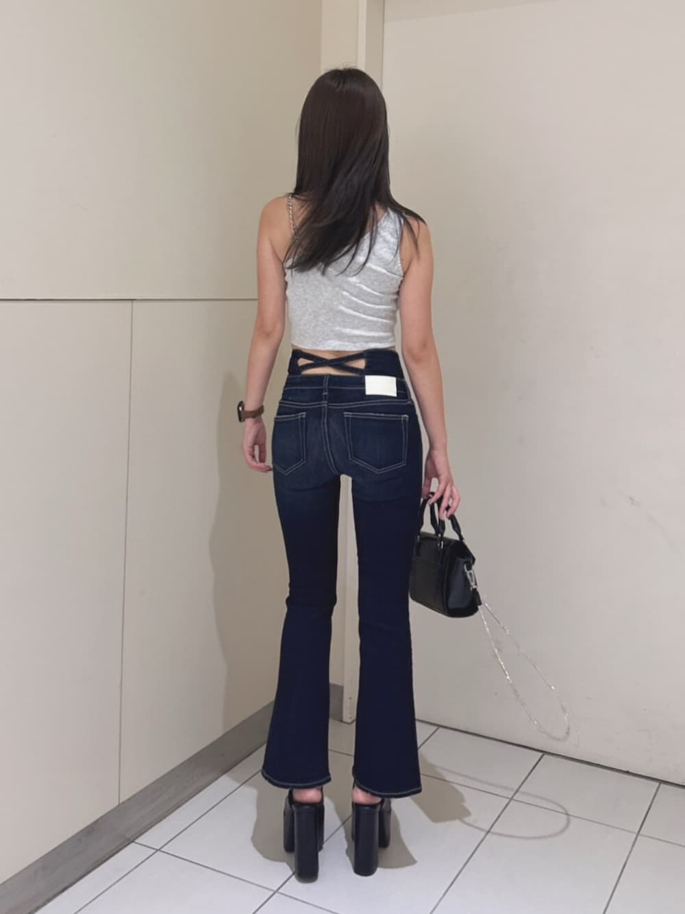 ブルー系のデニムパンツ、グレー系のタンクトップ、ブラック系のサンダルを着用したレディースの夏コーディネートの3枚目の写真