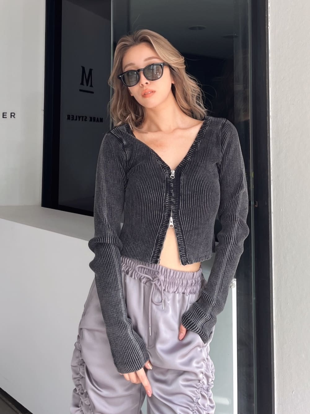 グレー系のその他パンツ、ブラック系のニット/セーター、ブラック系のブーツを着用したレディースの秋コーディネートの4枚目の写真