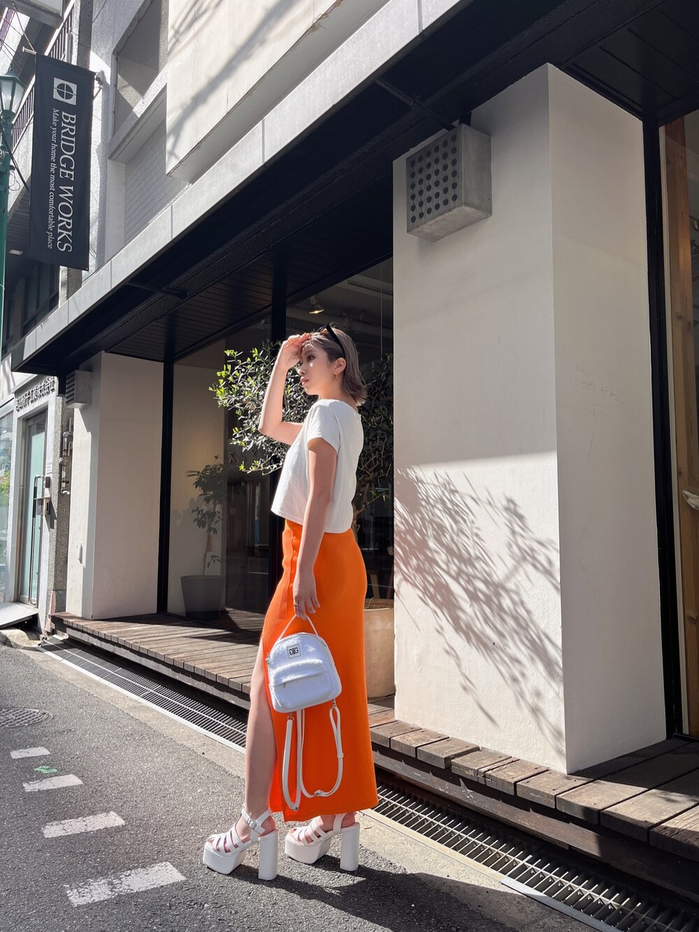 ホワイト系のTシャツ/カットソー、オレンジ系のスカートを着用したレディースの春コーディネートの4枚目の写真