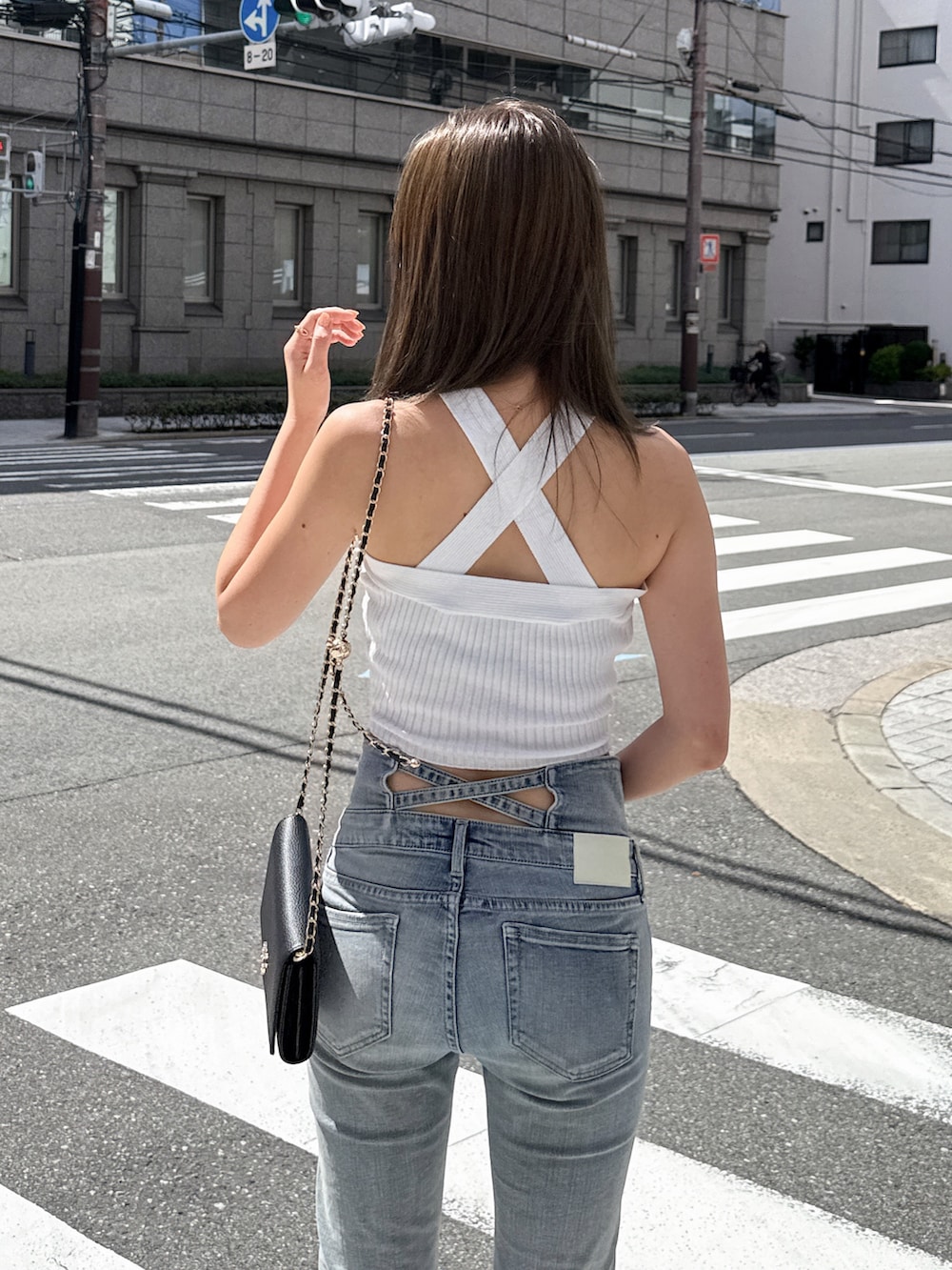 ホワイト系のタンクトップ、ブラック系のデニムパンツ、ブラック系のサンダルを着用したレディースの夏コーディネートの5枚目の写真