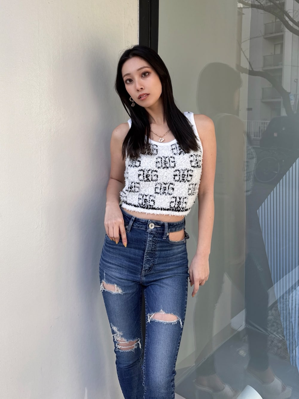 ホワイト系のニット/セーター、ブルー系のデニムパンツを着用したレディースの夏コーディネートの4枚目の写真