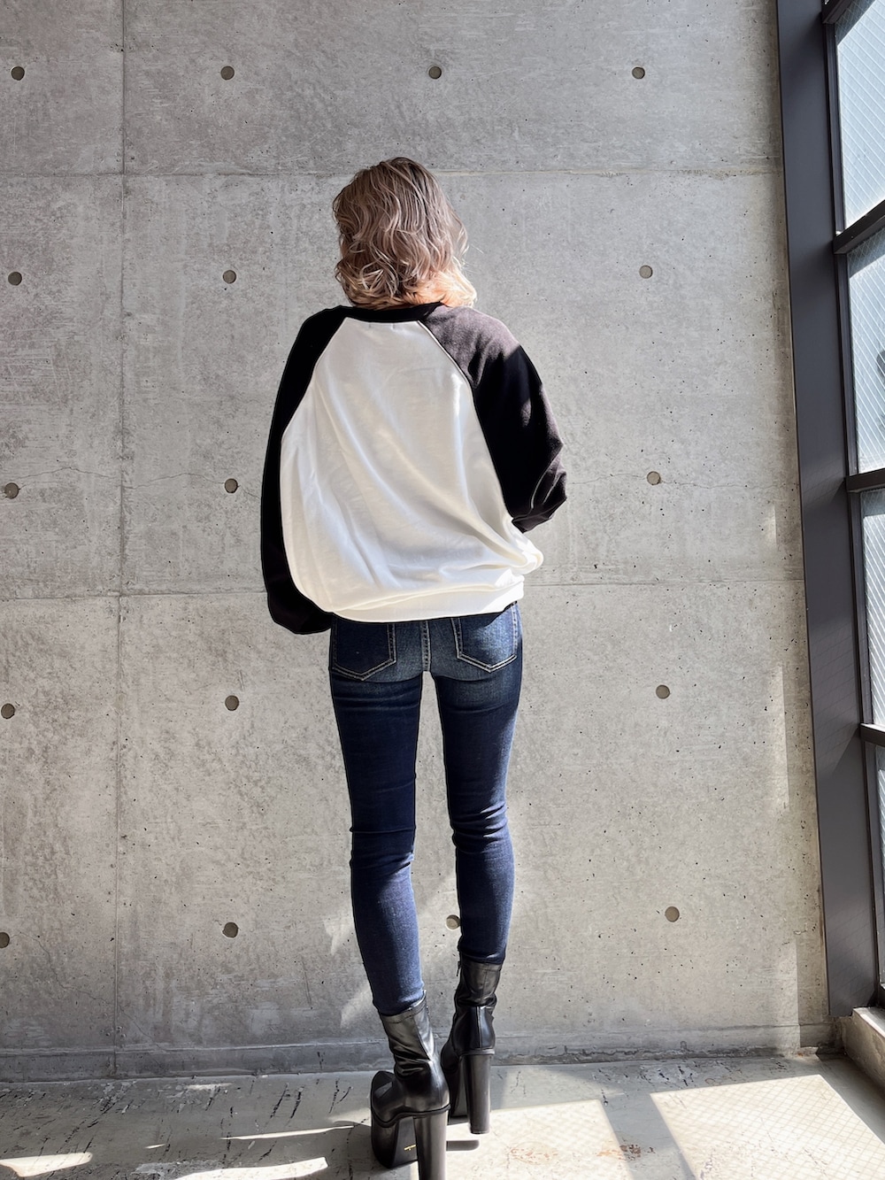 ブラック系のスウェット、ブラック系のブーツを着用したレディースの冬コーディネートの2枚目の写真