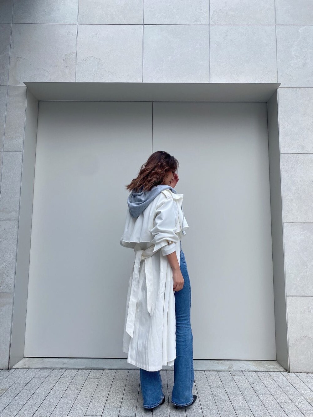 ブラック系のパンプス、ホワイト系のトレンチコート、ホワイト系のニット/セーターを着用したレディースの冬コーディネートの4枚目の写真