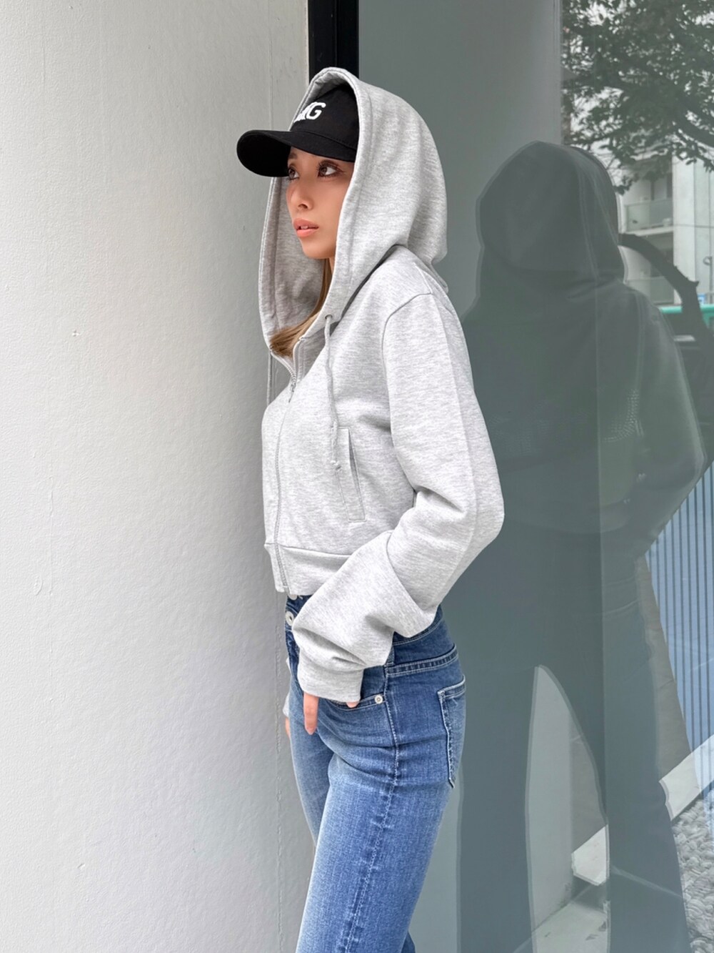 ブルー系のデニムパンツ、グレー系のパーカーを着用したレディースの春コーディネートの5枚目の写真