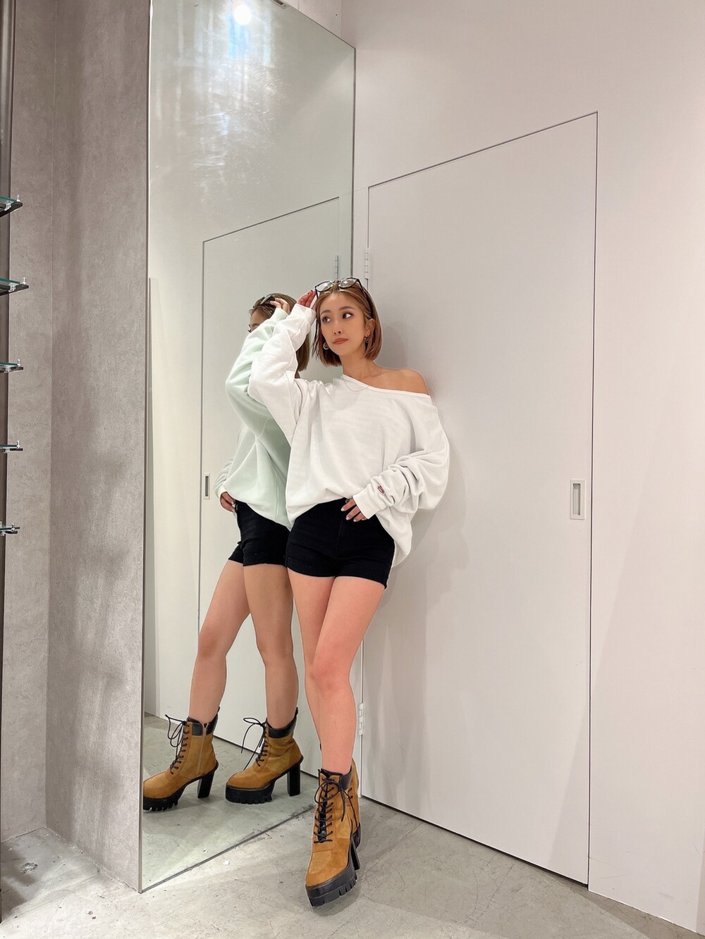 ホワイト系のスウェット、ブラウン系のブーツ、その他のサングラスを着用したレディースの秋コーディネートの2枚目の写真