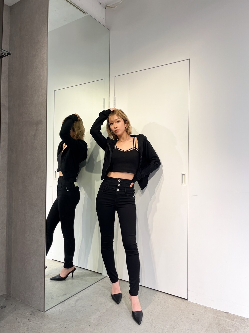 ブラック系のデニムパンツ、ブラック系のパーカー、ブラック系のキャミソールを着用したレディースの春コーディネートの2枚目の写真