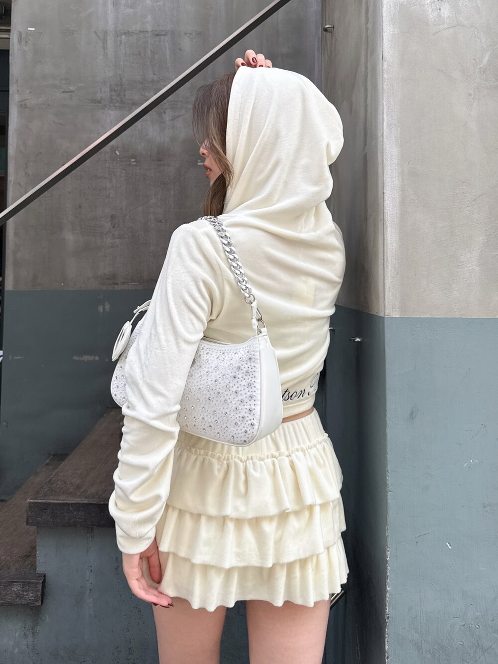 ホワイト系のパーカー、ホワイト系のその他パンツ、ホワイト系のハンドバッグを着用したレディースの秋コーディネートの3枚目の写真