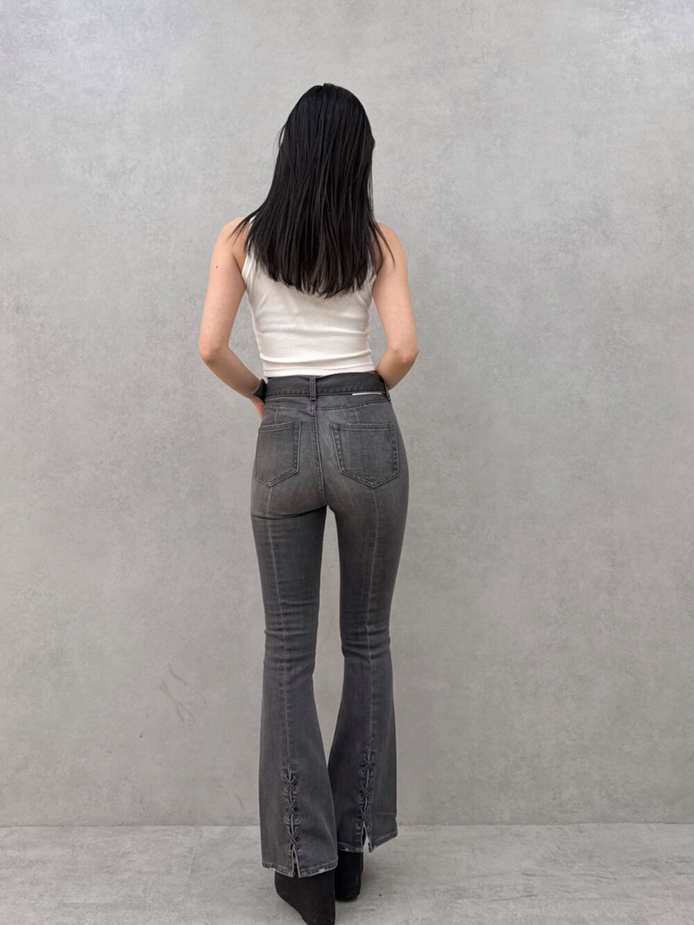 ブラック系のデニムパンツ、ホワイト系のタンクトップを着用したレディースの夏コーディネートの3枚目の写真