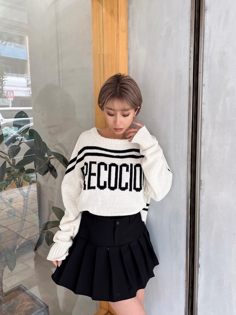 ホワイト系のニット/セーター、ブラック系のスカート、ブラック系のブーツを着用したレディースの冬コーディネートの2枚目の写真