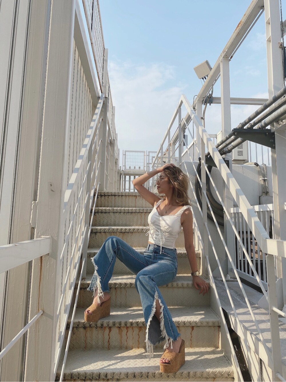 ベージュ系のサンダル、ブルー系のデニムパンツ、ホワイト系のシャツ/ブラウスを着用したレディースの夏コーディネートの4枚目の写真