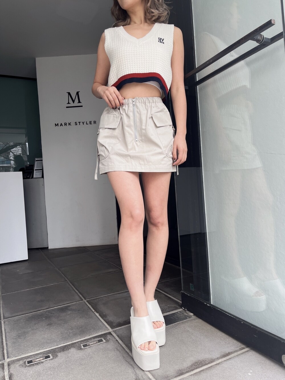 ホワイト系のニット/セーター、ホワイト系のカーゴパンツ、ブラック系のサンダルを着用したレディースの秋コーディネートの4枚目の写真