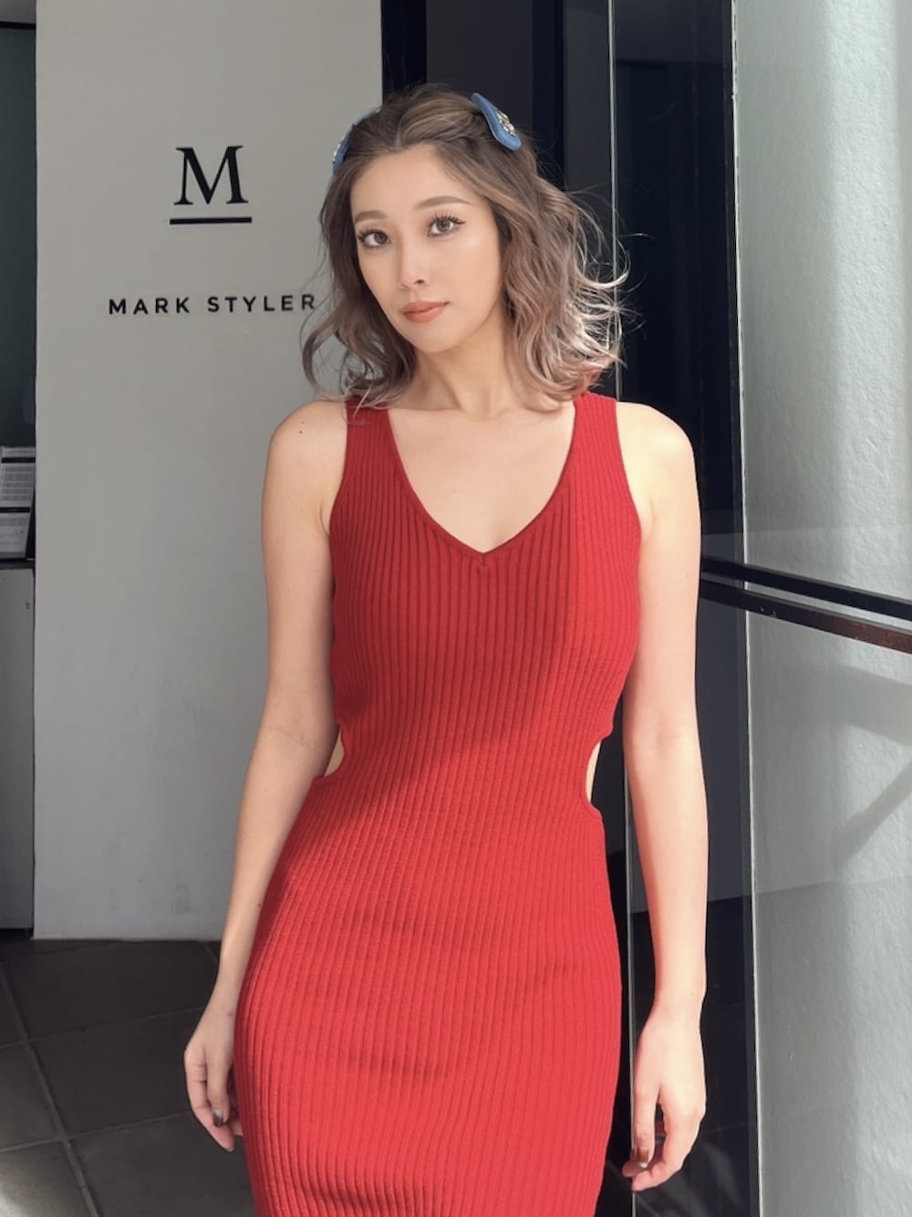 レッド系のワンピース、ブラック系のサンダル、ブルー系のバレッタ/ヘアクリップを着用したレディースの夏コーディネートの2枚目の写真