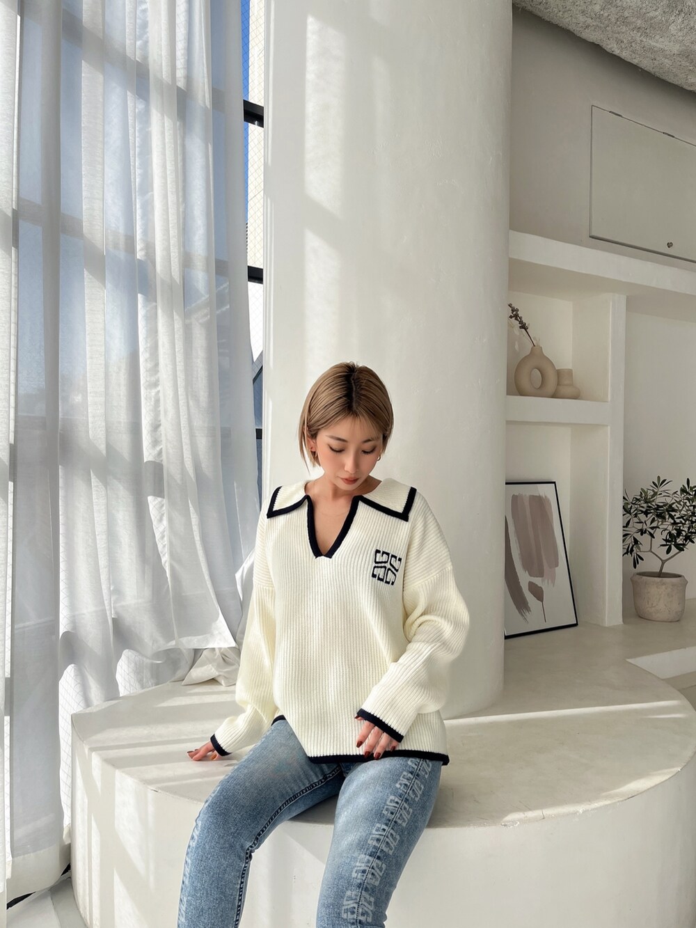 ホワイト系のニット/セーター、ホワイト系のパンプス、ブルー系のパンツを着用したレディースの冬コーディネートの3枚目の写真