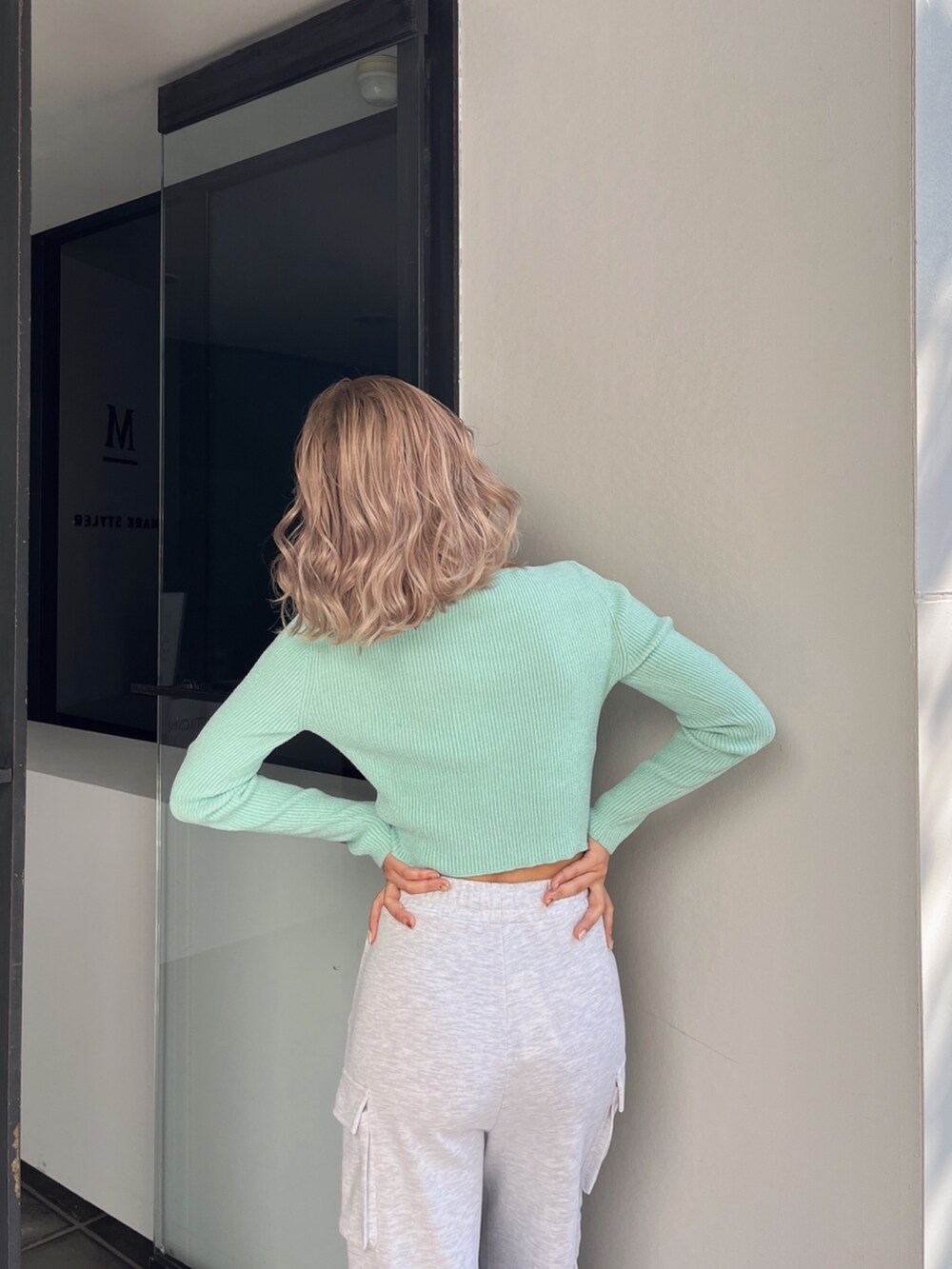 グレー系のカーゴパンツ、グリーン系のカーディガン/ボレロ、ベージュ系のパンプスを着用したレディースの冬コーディネートの8枚目の写真