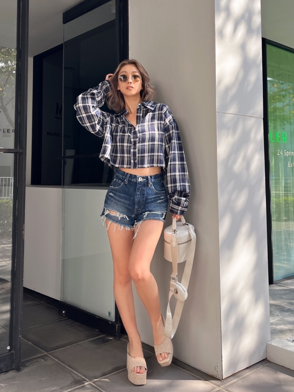 ブルー系のシャツ/ブラウス、ブラック系のハンドバッグ、ブラウン系のサングラスを着用したレディースの春コーディネートの5枚目の写真