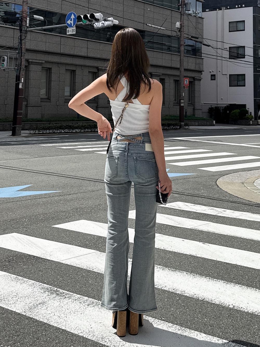 ホワイト系のタンクトップ、ブラック系のデニムパンツ、ブラック系のサンダルを着用したレディースの夏コーディネートの3枚目の写真