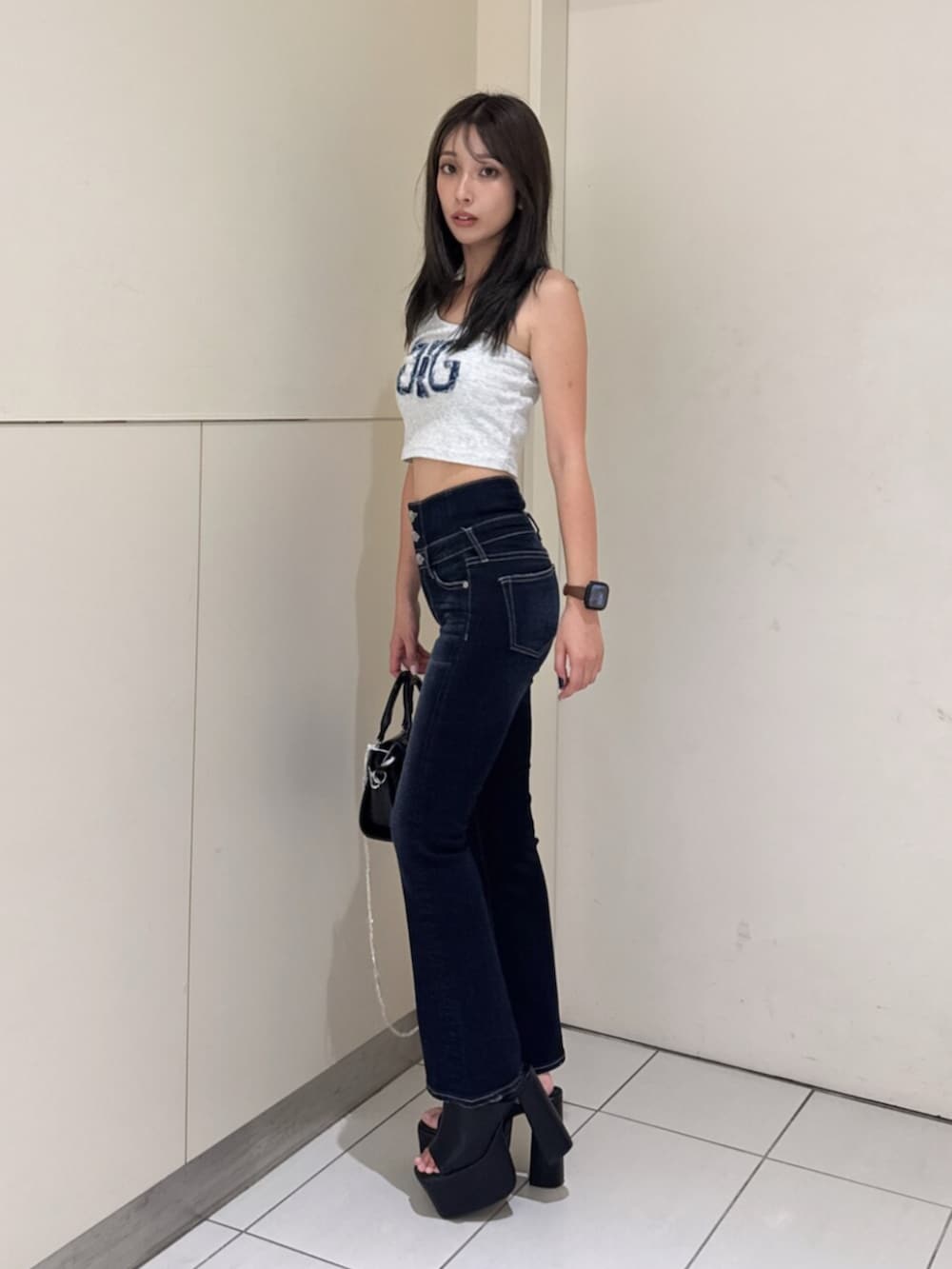 ブルー系のデニムパンツ、グレー系のタンクトップ、ブラック系のサンダルを着用したレディースの夏コーディネートの2枚目の写真