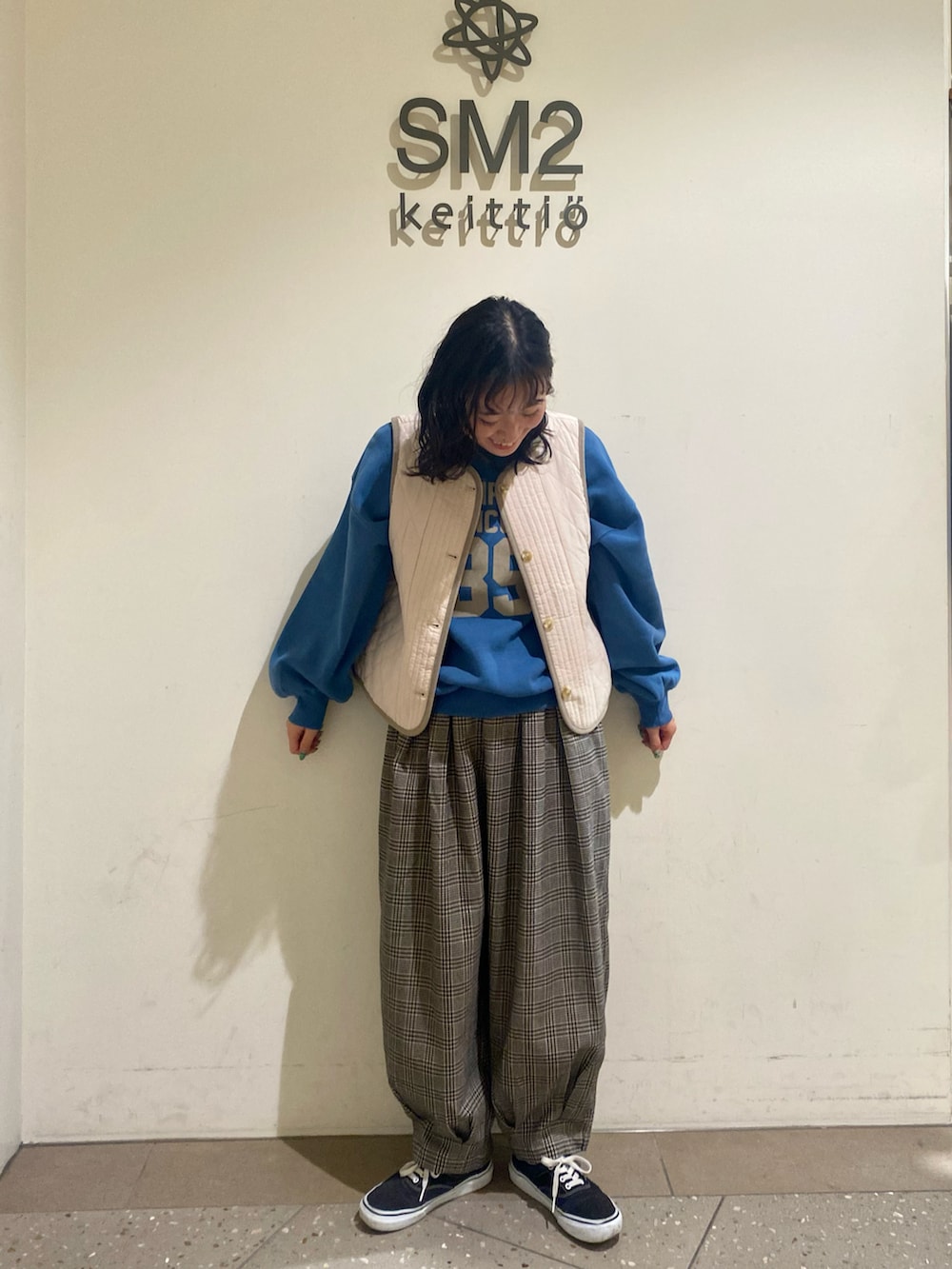 ブラック系のその他パンツ、ブルー系のTシャツ/カットソー、ホワイト系のベストを着用したレディースの冬コーディネートの2枚目の写真