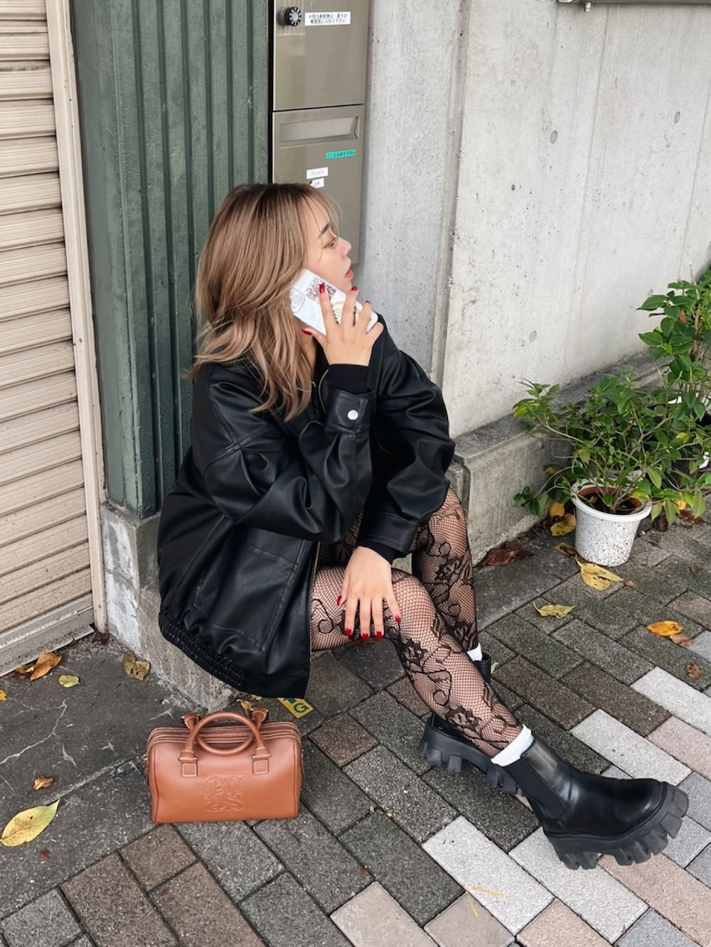 ブラック系のブルゾン、ブラック系のブーツ、ブラウン系のボストンバッグを着用したレディースの秋コーディネートの4枚目の写真