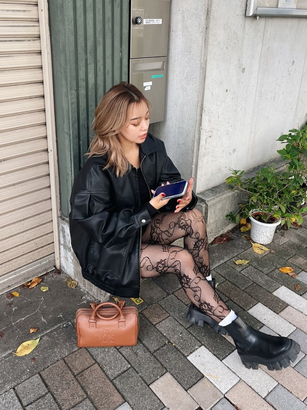 ブラック系のブルゾン、ブラック系のブーツ、ブラウン系のボストンバッグを着用したレディースの秋コーディネートの3枚目の写真