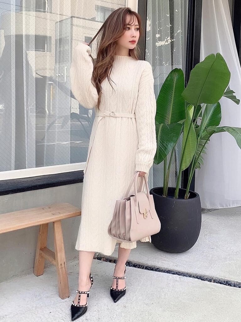 ホワイト系のワンピース、ブラック系のパンプス、ベージュ系のハンドバッグを着用したレディースの冬コーディネートの3枚目の写真