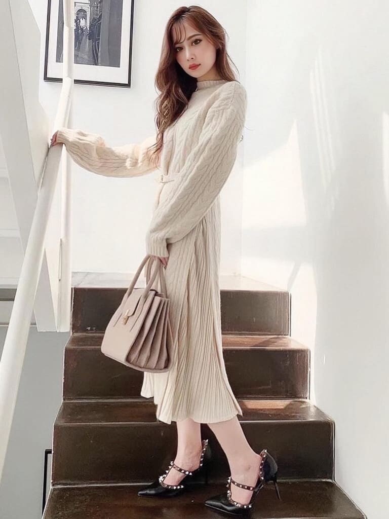 ホワイト系のワンピース、ブラック系のパンプス、ベージュ系のハンドバッグを着用したレディースの冬コーディネートの2枚目の写真