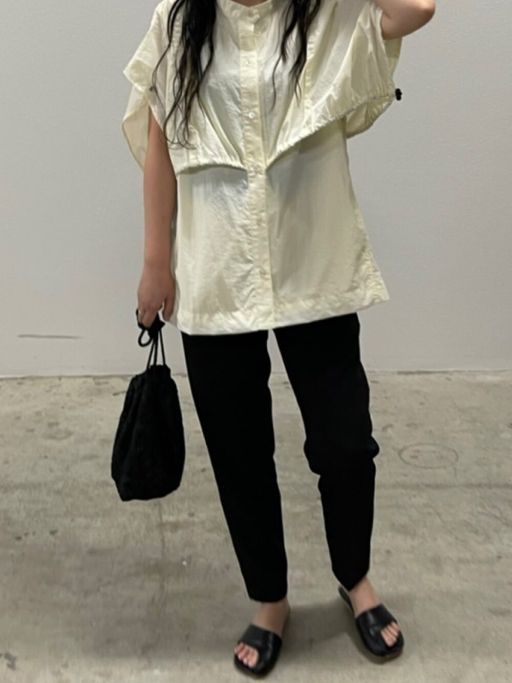 ブラック系のショルダーバッグ、ブラック系のサンダル、ホワイト系のTシャツ/カットソーを着用したレディースの夏コーディネートの3枚目の写真