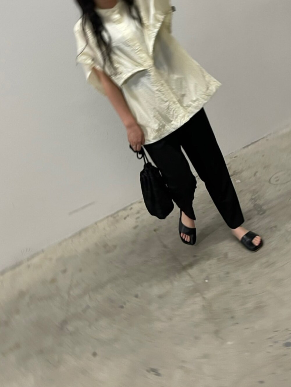 ブラック系のショルダーバッグ、ブラック系のサンダル、ホワイト系のTシャツ/カットソーを着用したレディースの夏コーディネートの4枚目の写真