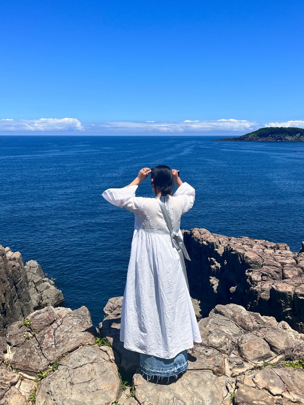 ホワイト系のワンピース/ドレス、ブルー系のデニムスカート、シルバー系のバッグを着用したレディースの夏コーディネートの2枚目の写真