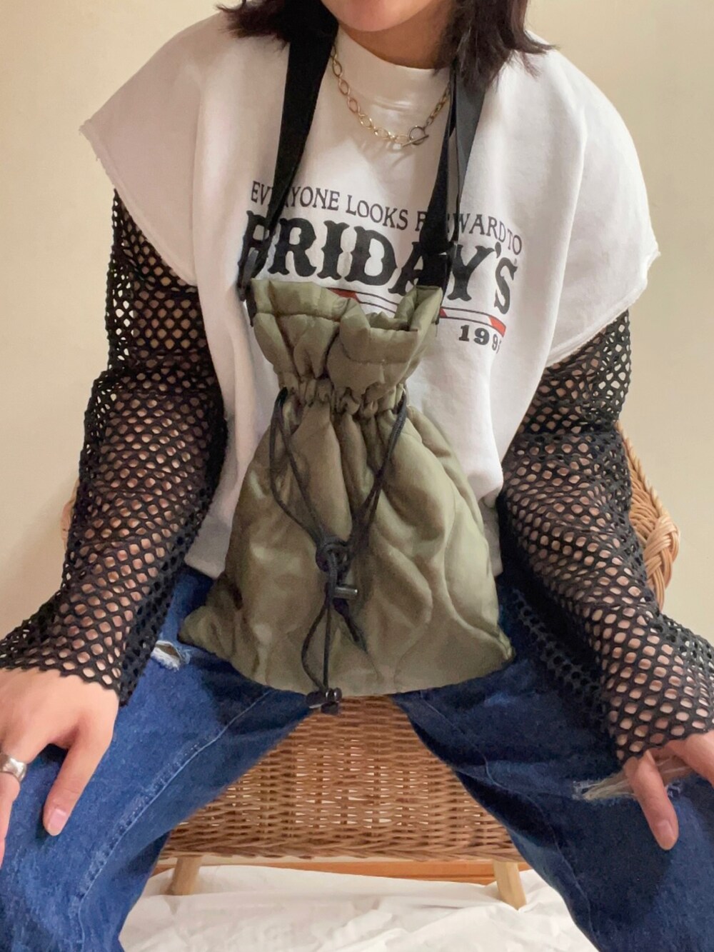 ブルー系のデニムパンツ、グリーン系のショルダーバッグ、ブラック系のキャップを着用したレディースの秋コーディネートの2枚目の写真