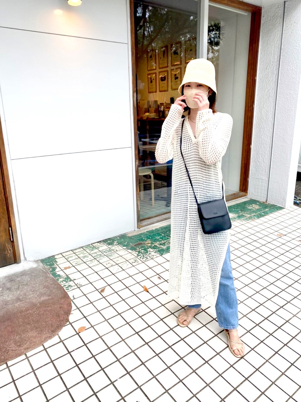 ホワイト系のワンピース/ドレス、ブルー系のデニムパンツ、ゴールド系のサンダルを着用したレディースの夏コーディネートの2枚目の写真