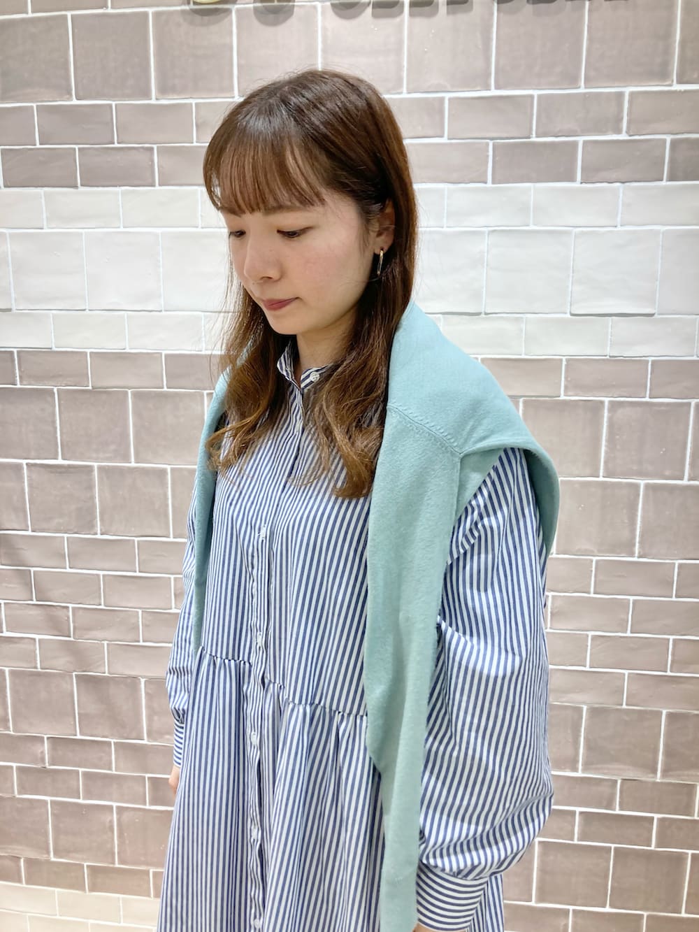 ブルー系のワンピース、グリーン系のカーディガン/ボレロ、ベージュ系のローファーを着用したレディースの冬コーディネートの3枚目の写真