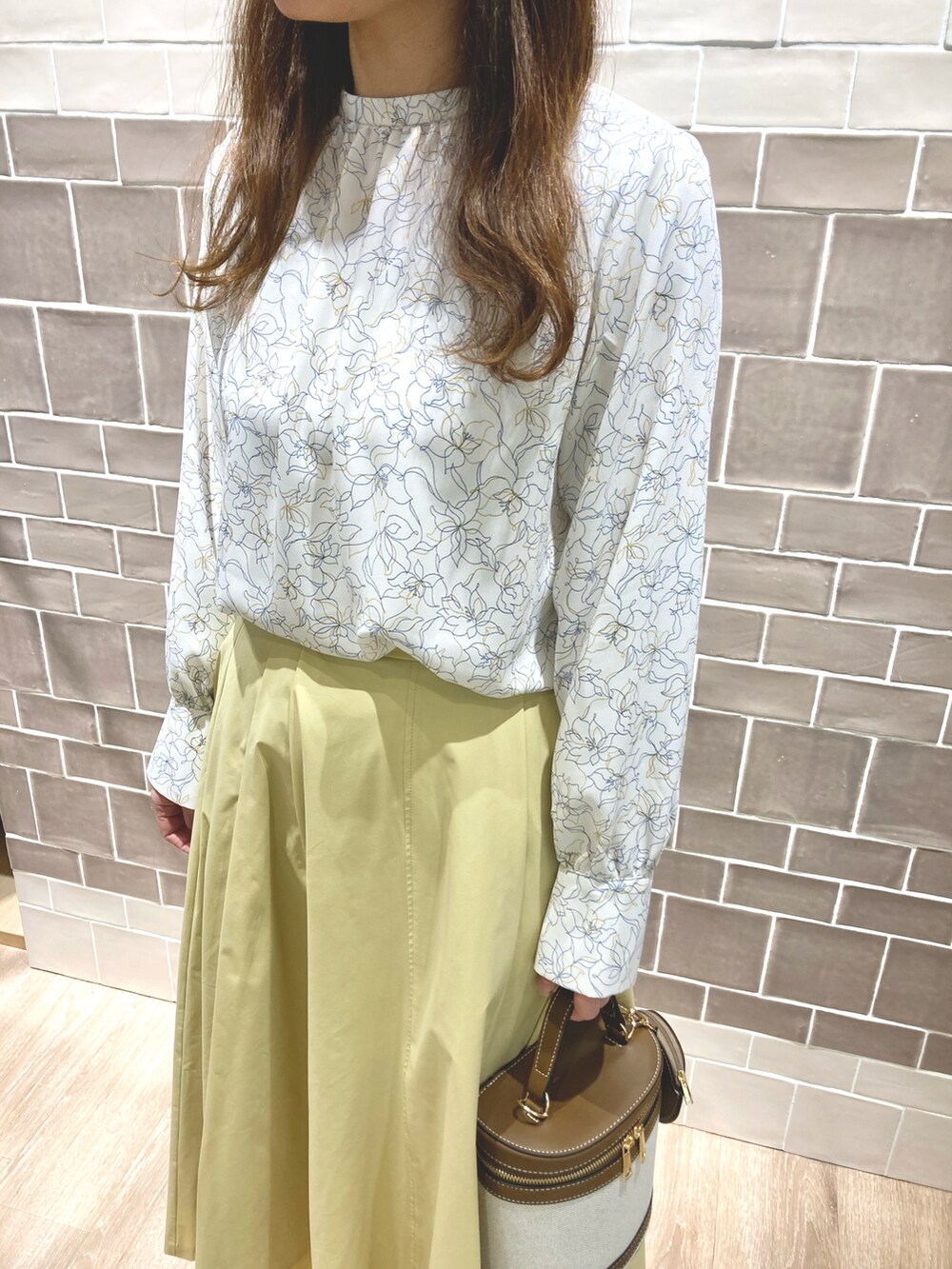 ホワイト系のシャツ/ブラウス、イエロー系のスカート、ブラウン系のショルダーバッグを着用したレディースの春コーディネートの3枚目の写真