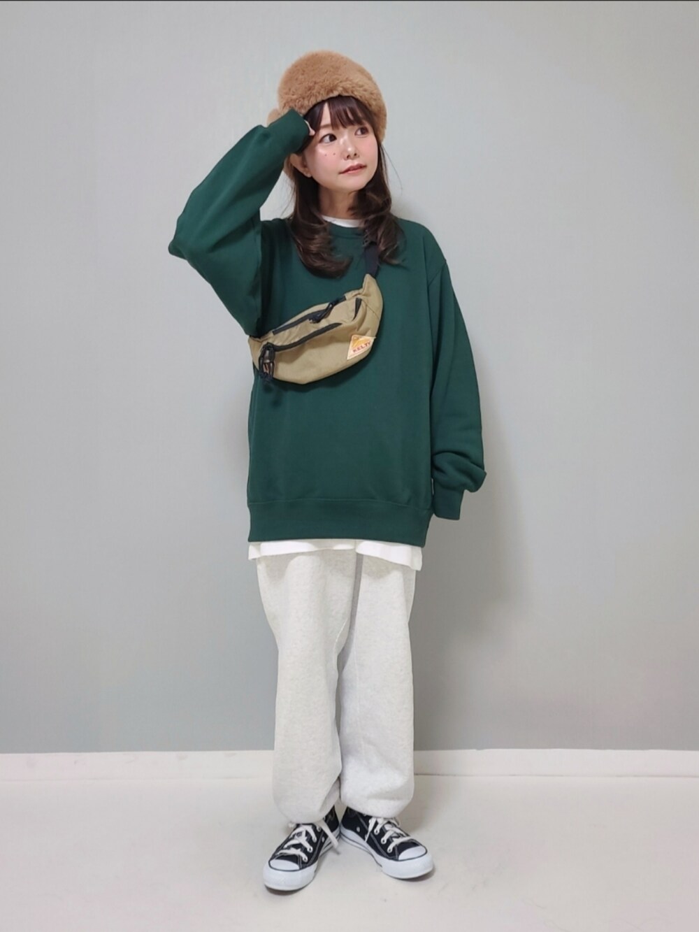 グリーン系のスウェット、ホワイト系のTシャツ/カットソー、グレー系のスウェットパンツを着用したレディースの冬コーディネートの2枚目の写真