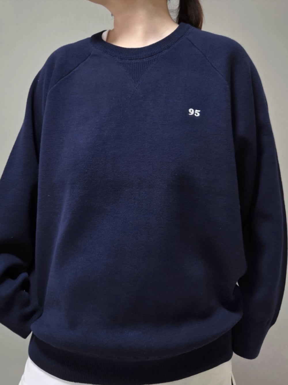 ブルー系のニット/セーターを着用したレディースの秋コーディネートの5枚目の写真