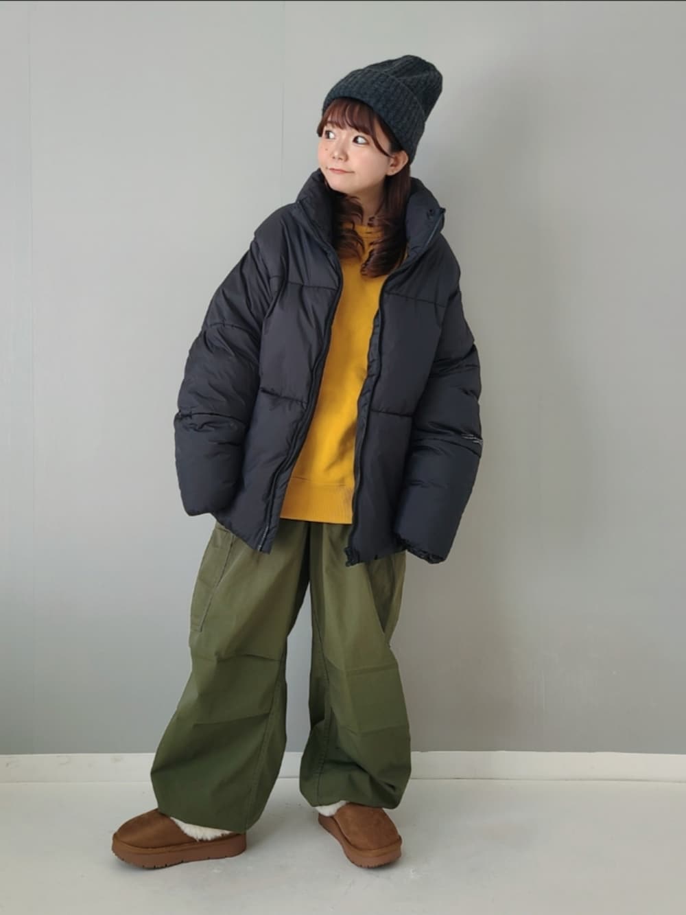 ブラック系のダウンジャケット/コート、イエロー系のスウェット、グリーン系のカーゴパンツを着用したレディースの秋コーディネートの3枚目の写真