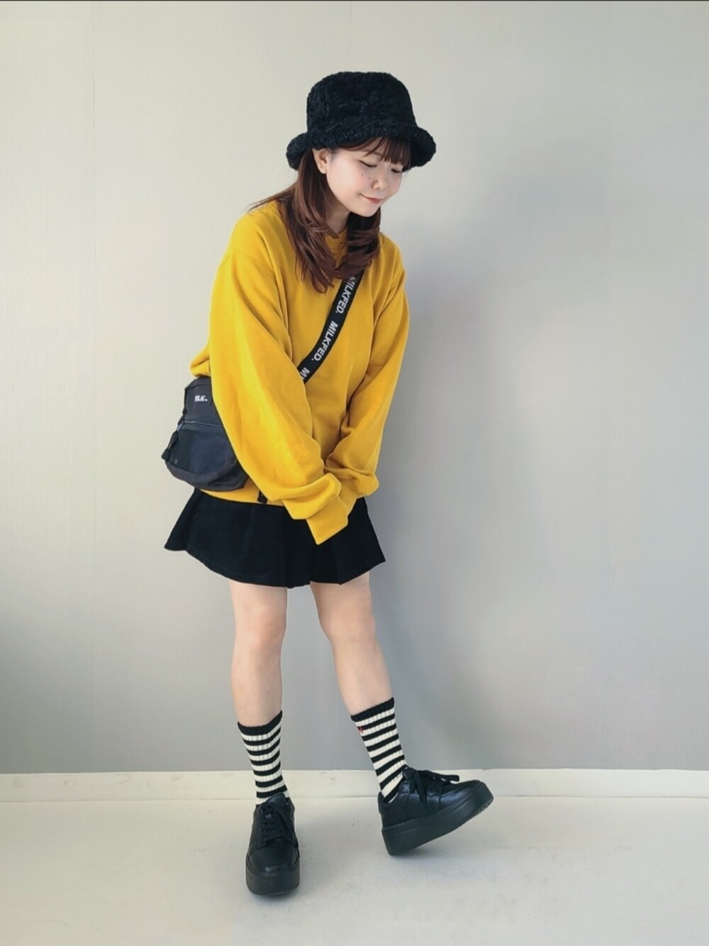 イエロー系のスウェット、ブラック系のその他パンツ、ブラック系のショルダーバッグを着用したレディースの秋コーディネートの3枚目の写真