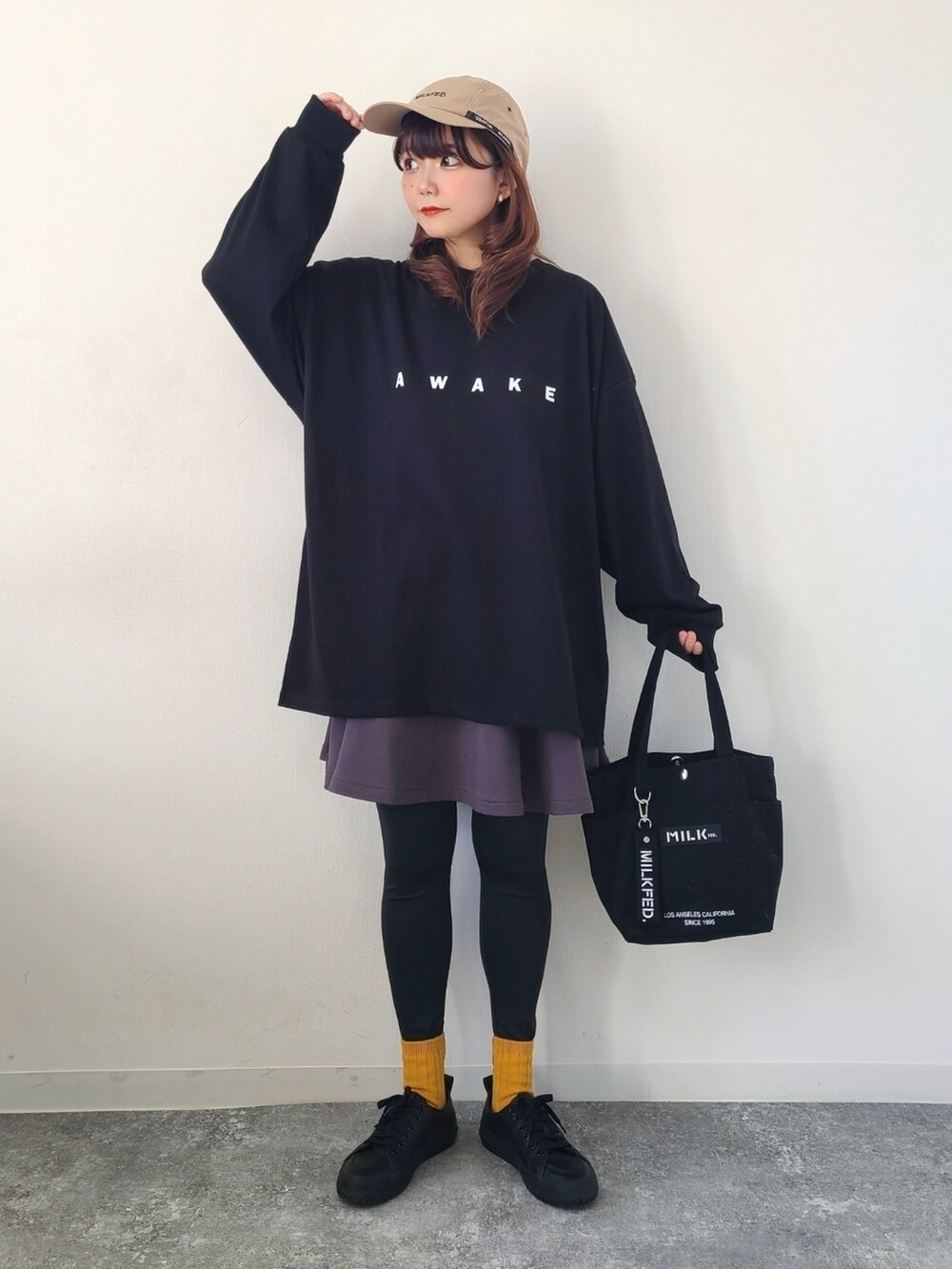 ブラック系のTシャツ/カットソー、グレー系のスカート、ブラック系のトートバッグを着用したレディースの春コーディネートの2枚目の写真