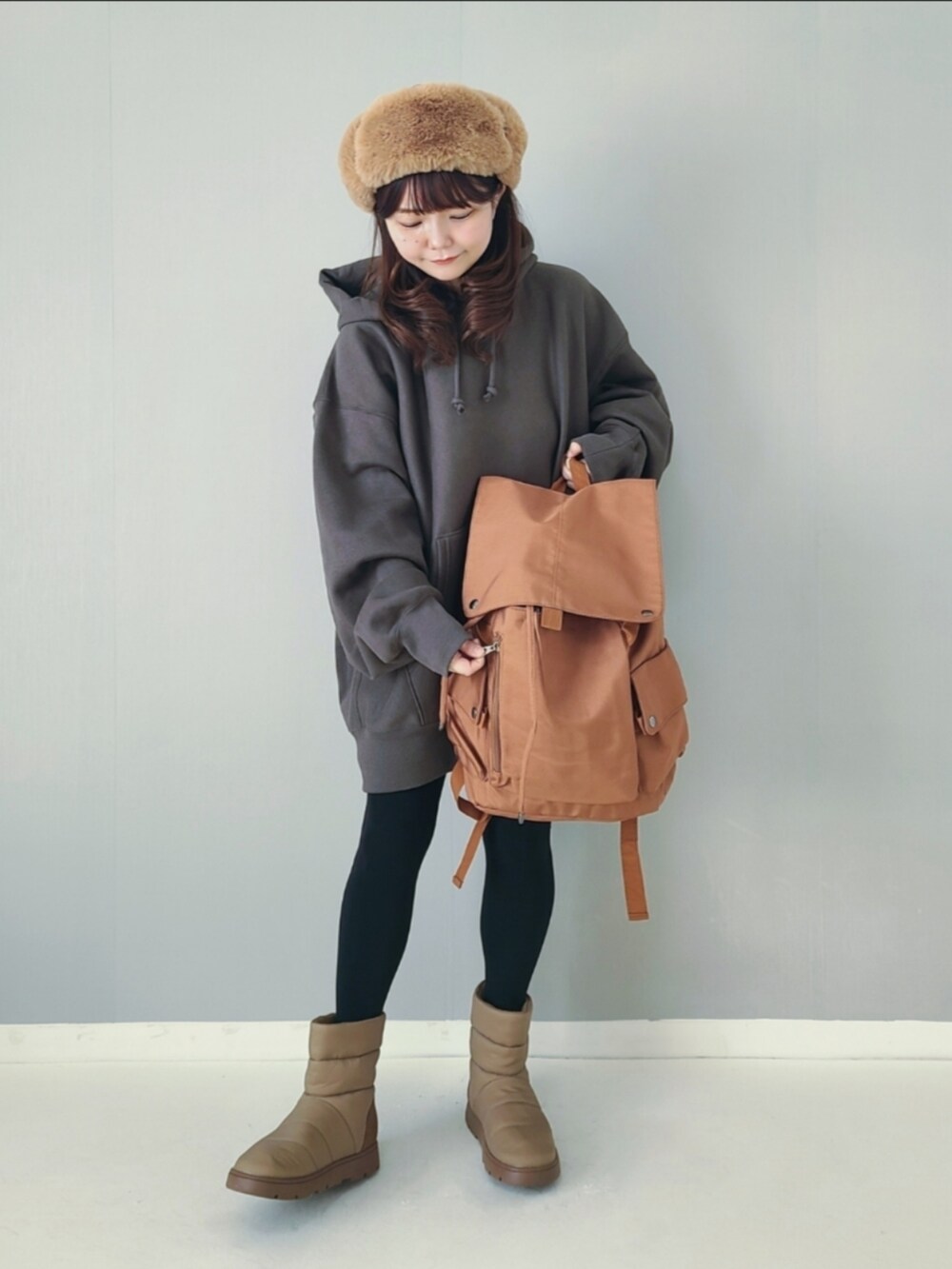 ブラウン系のバックパック/リュック、グリーン系のパーカー、ベージュ系のブーツを着用したレディースの秋コーディネートの3枚目の写真