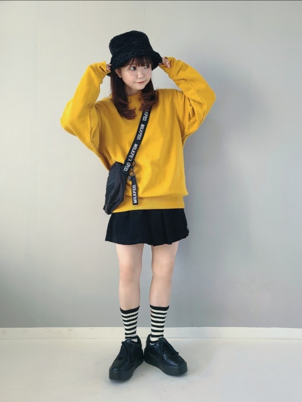 イエロー系のスウェット、ブラック系のその他パンツ、ブラック系のショルダーバッグを着用したレディースの秋コーディネートの2枚目の写真