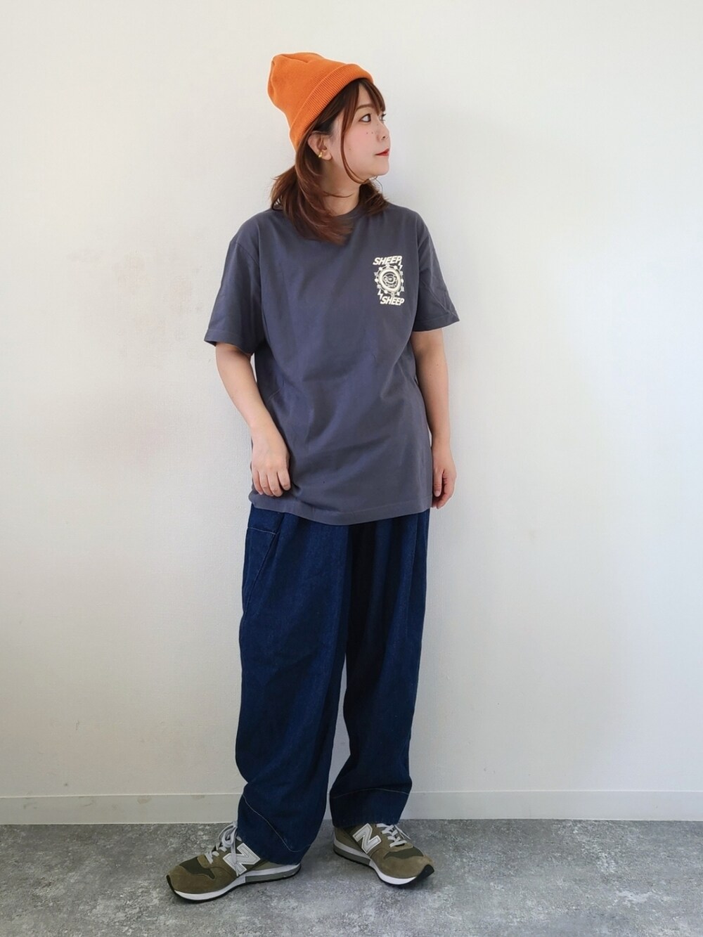 グレー系のTシャツ/カットソー、ブルー系のデニムパンツ、グリーン系のスニーカーを着用したレディースの秋コーディネートの5枚目の写真