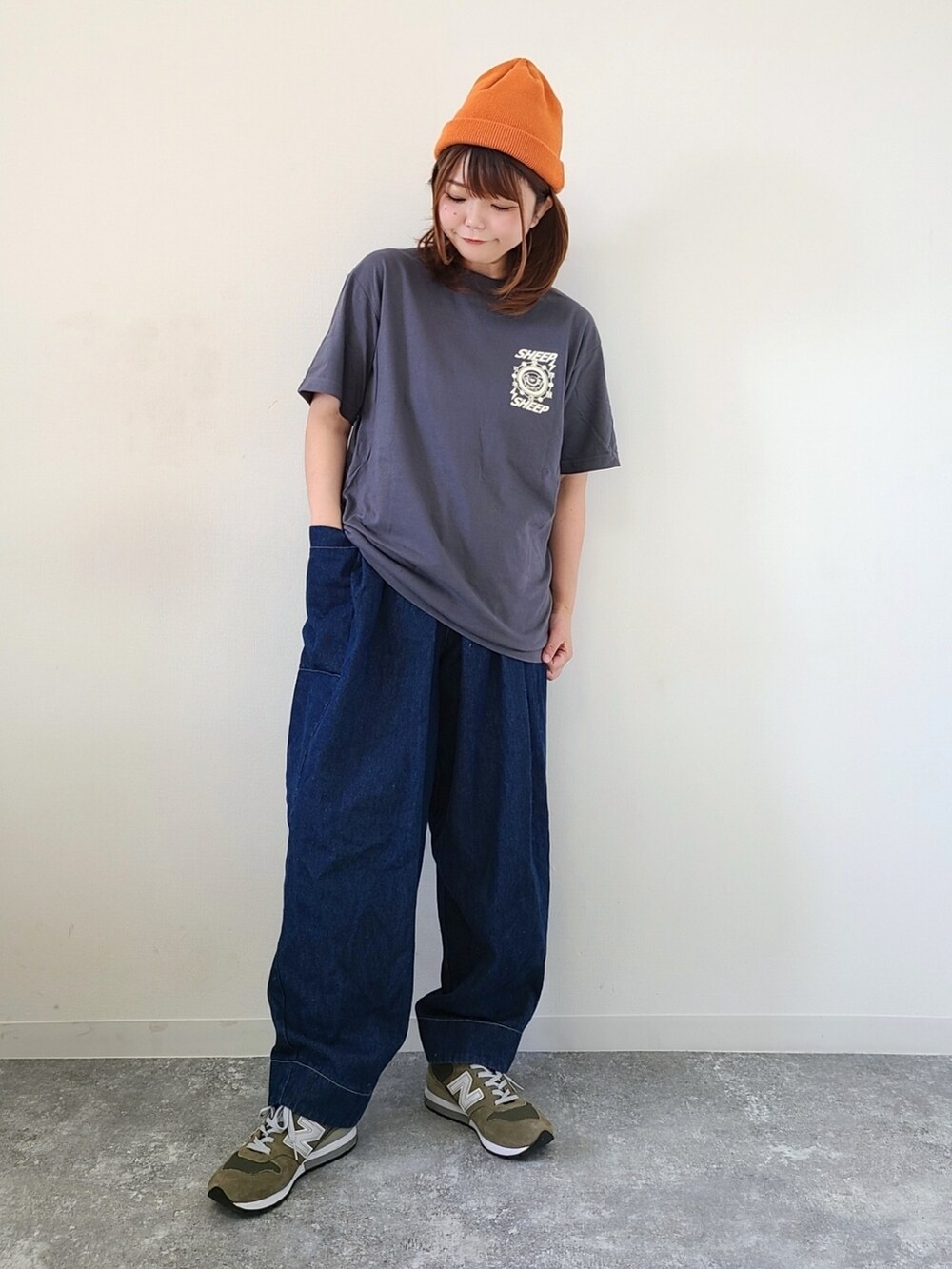 グレー系のTシャツ/カットソー、ブルー系のデニムパンツ、グリーン系のスニーカーを着用したレディースの秋コーディネートの4枚目の写真