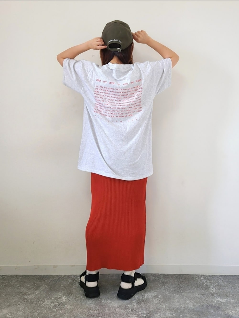 ベージュ系のTシャツ/カットソー、オレンジ系のスカート、ブラック系のサンダルを着用したレディースの春コーディネートの3枚目の写真