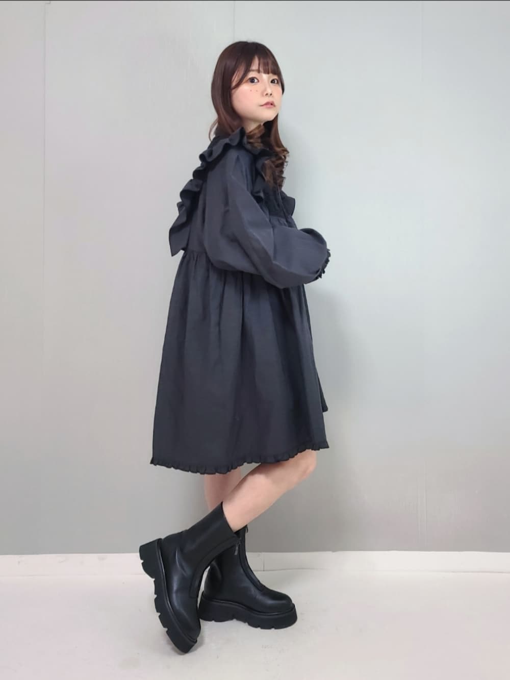 ブラック系のワンピース、ブラック系のブーツを着用したレディースの冬コーディネートの4枚目の写真