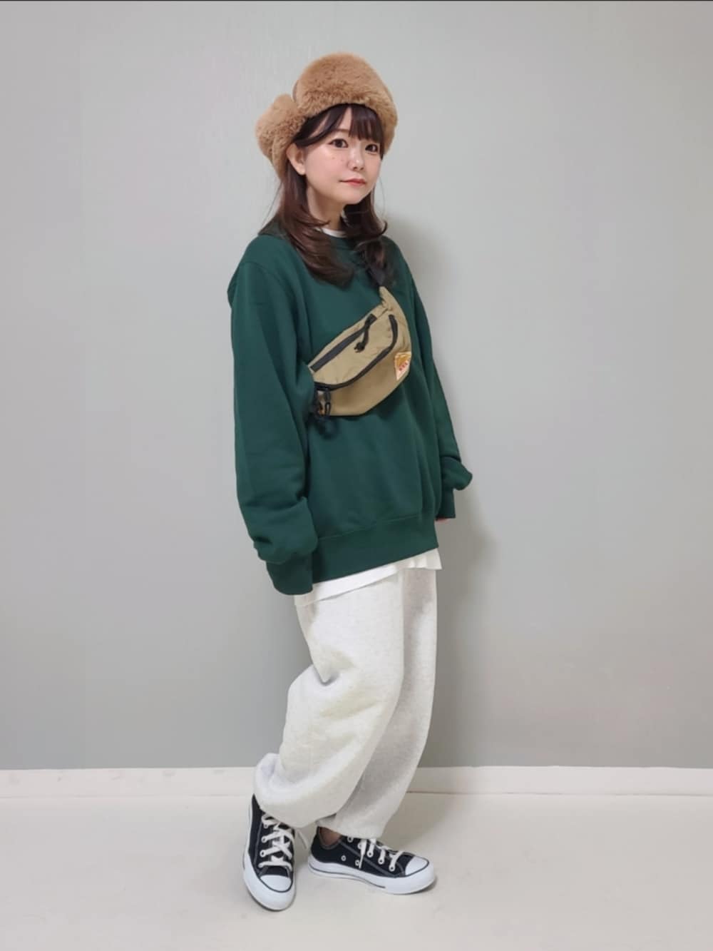 グリーン系のスウェット、ホワイト系のTシャツ/カットソー、グレー系のスウェットパンツを着用したレディースの冬コーディネートの4枚目の写真