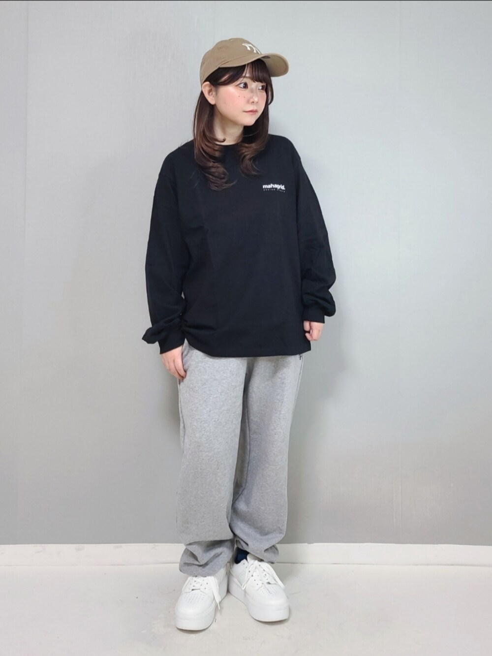 ブラック系のTシャツ/カットソー、グレー系のスウェットパンツ、ホワイト系のスニーカーを着用したレディースの冬コーディネートの2枚目の写真