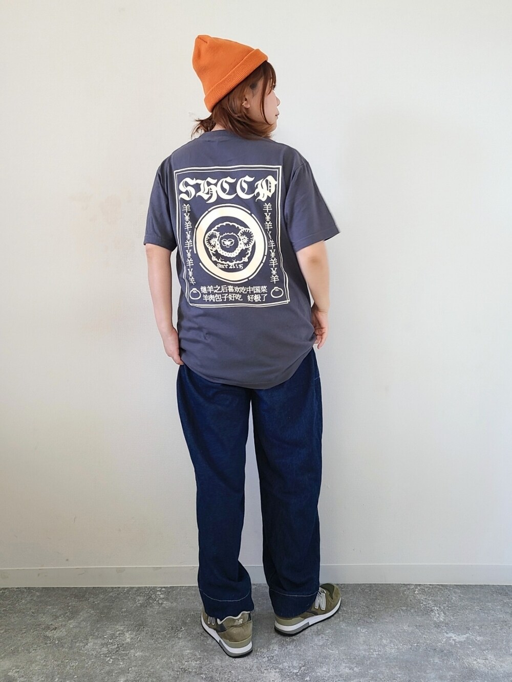 グレー系のTシャツ/カットソー、ブルー系のデニムパンツ、グリーン系のスニーカーを着用したレディースの秋コーディネートの3枚目の写真